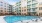 Urban Apartments for Rent in University City, NC - Mason - Outdoor Courtyard with Pool, Spacious Sun Deck, Submerged and Poolside Lounge Chairs, and View of Apartment Building.