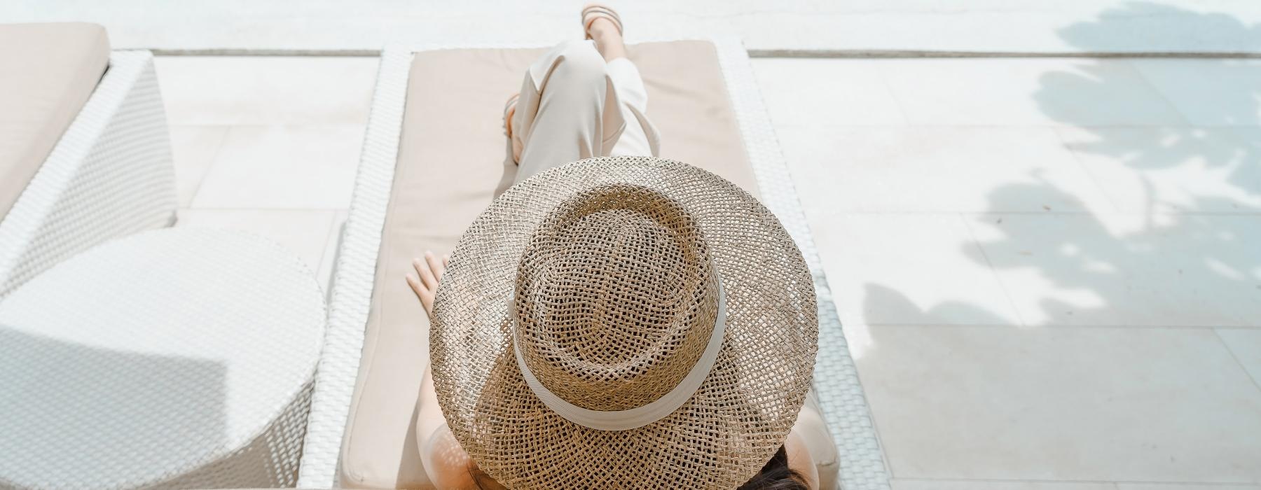a person lying on a chair by a pool